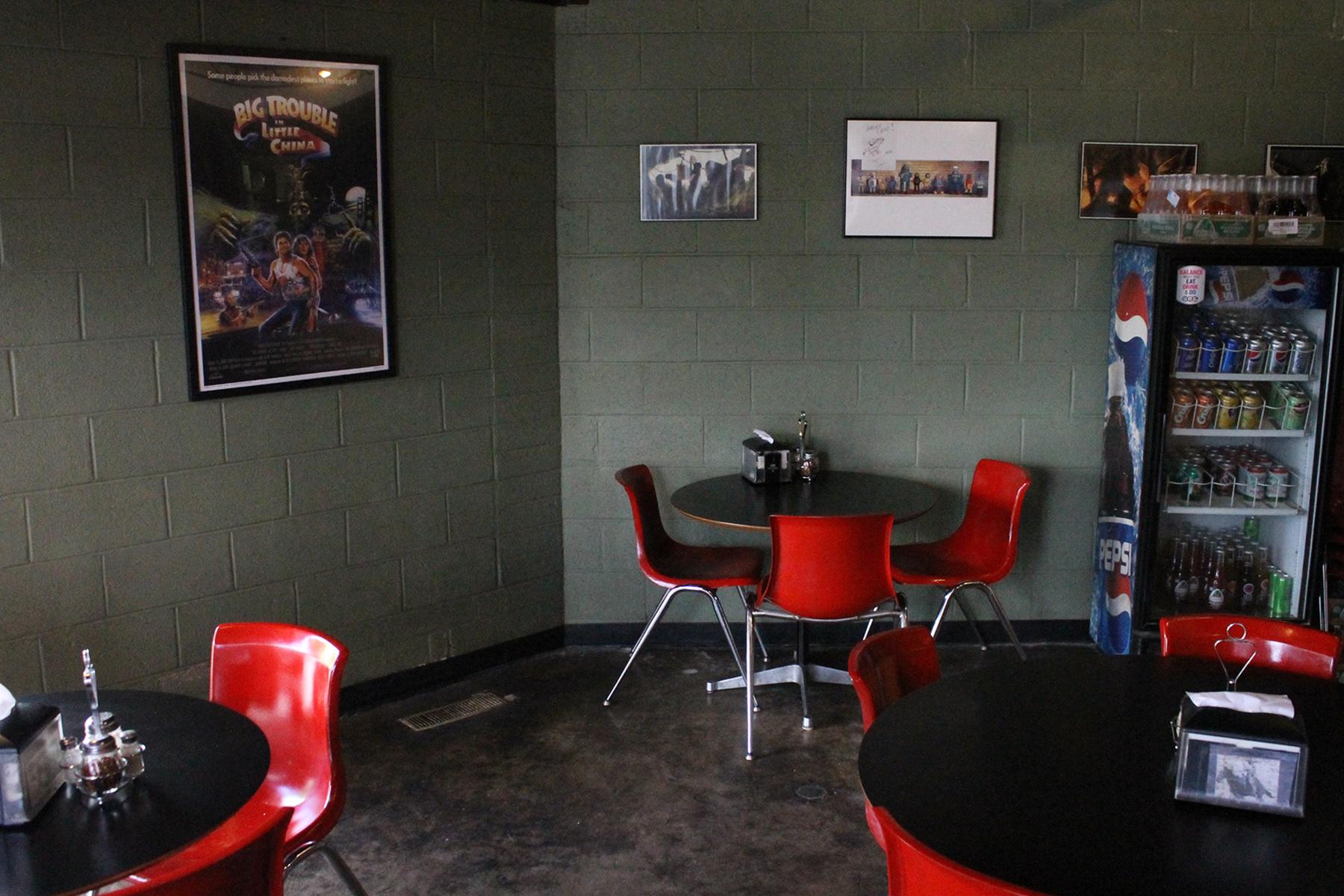 PieHole's dining room with red chairs and artwork on dark walls