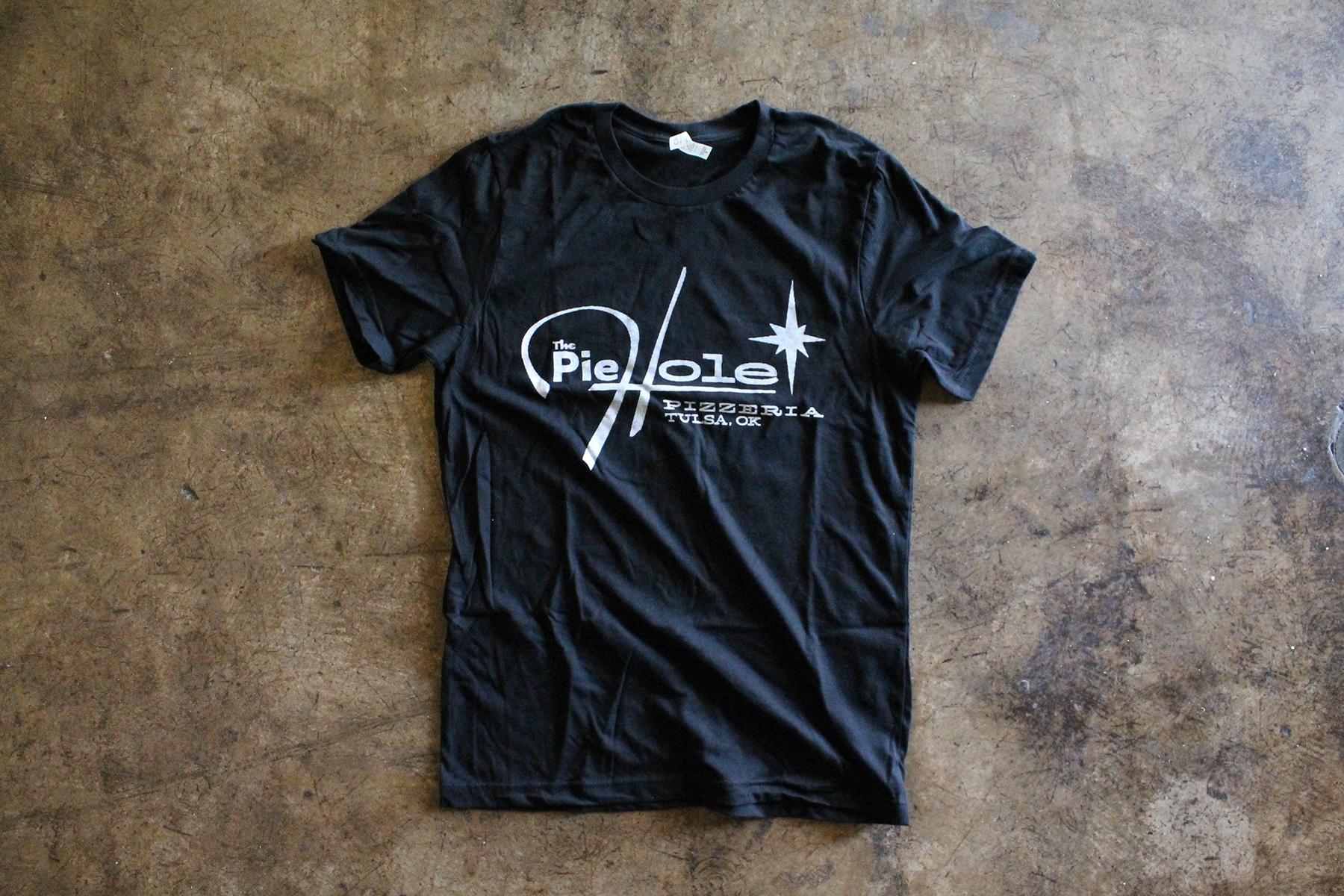 A black T-shirt printed with the PieHole Pizzeria logo